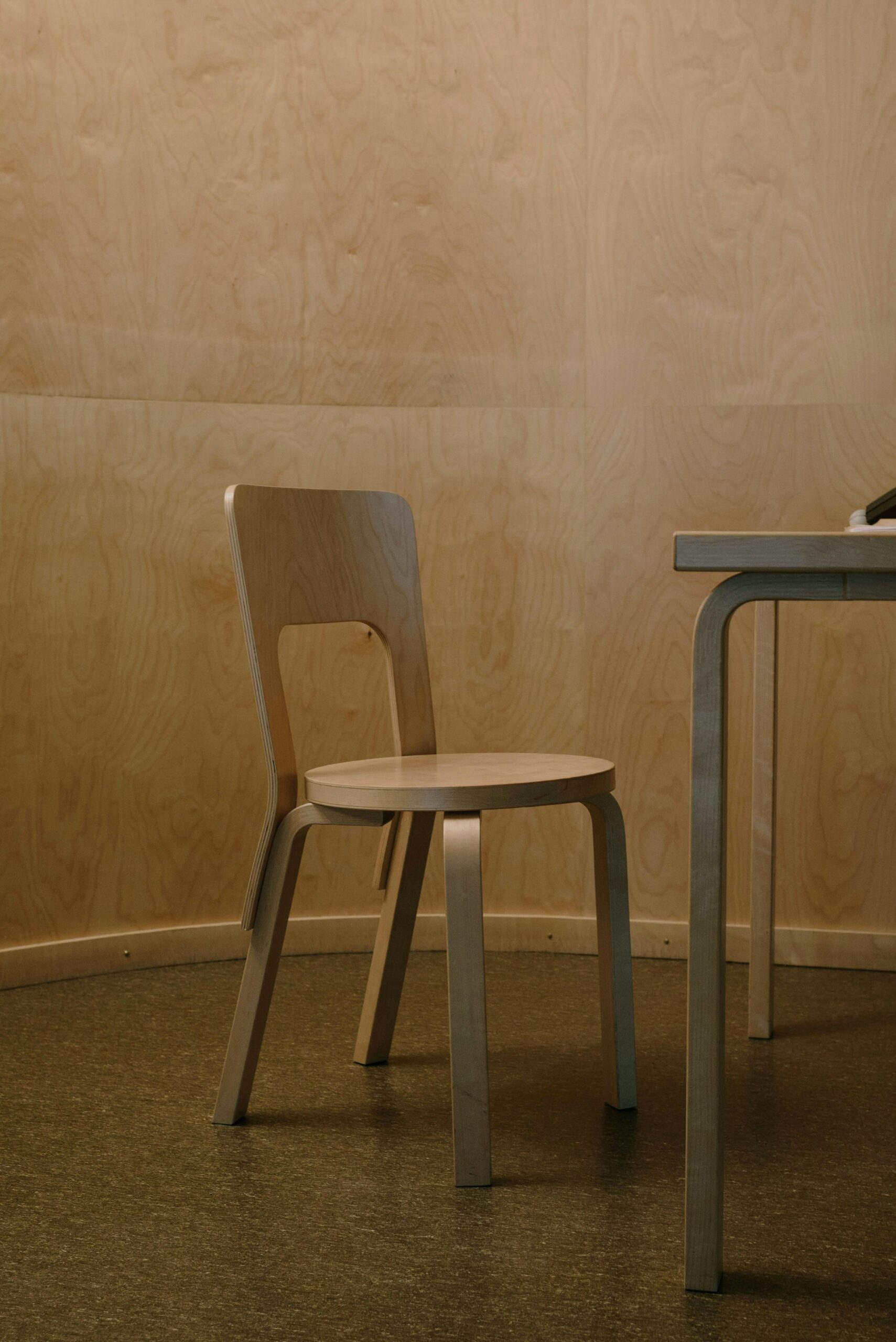 A modern minimalist room featuring a wooden chair and table. Perfect for lifestyle and interior design themes.